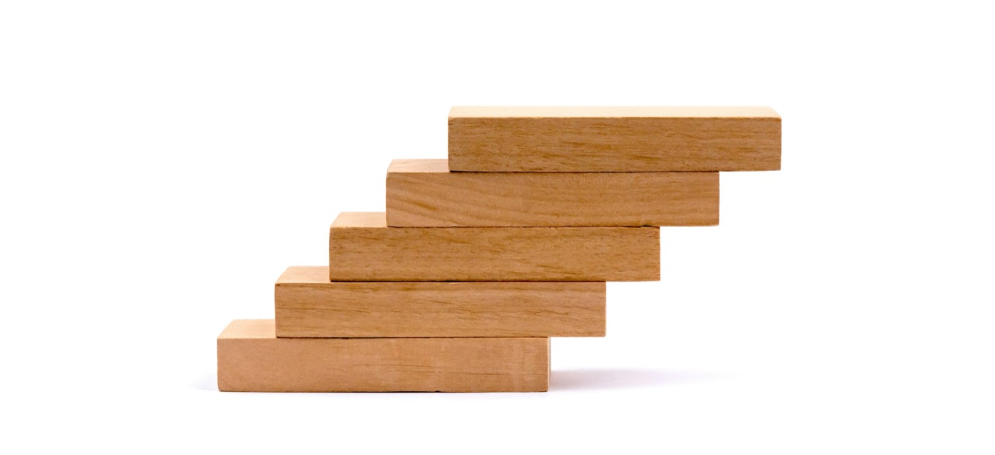 Holzbausteine als aufsteigende Treppe gestapelt